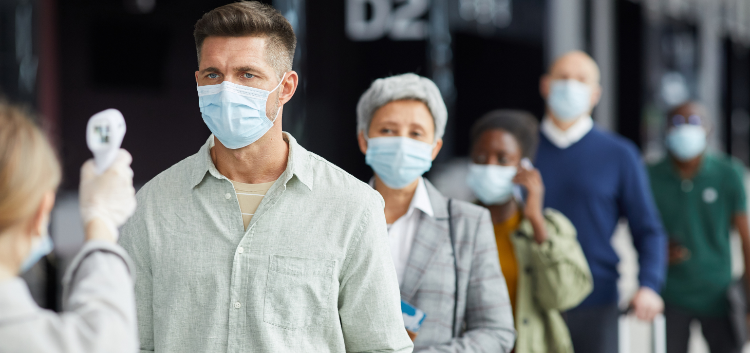 people in masks having temperature checked